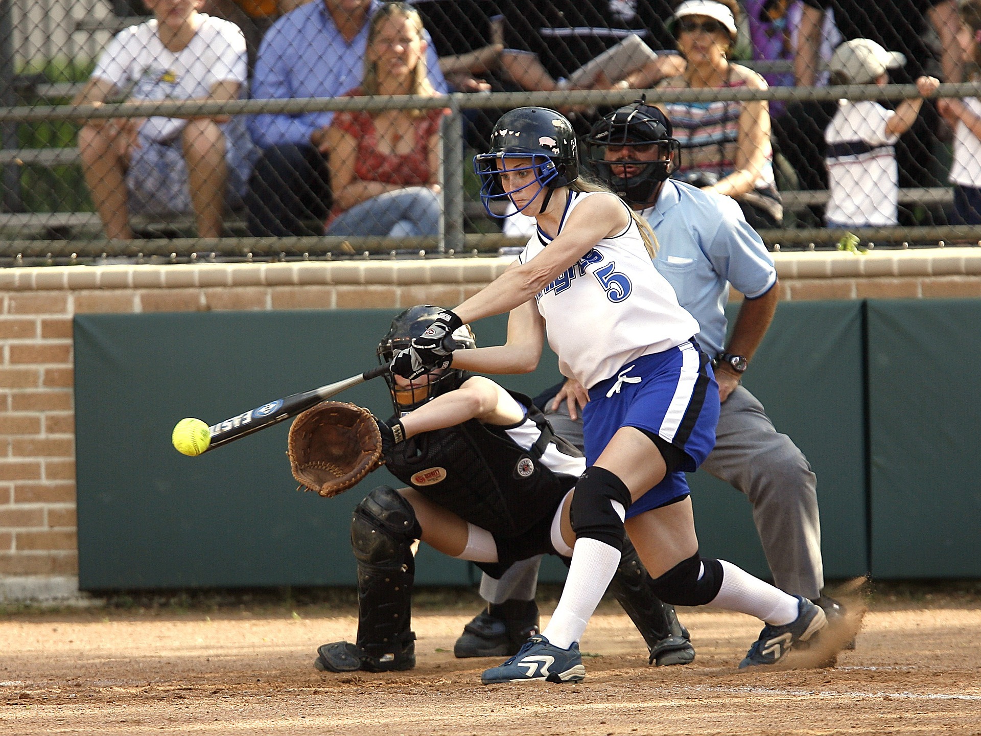 Women hitting softball with bat